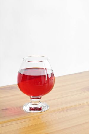Red wine in a glass on a wooden tableの写真素材