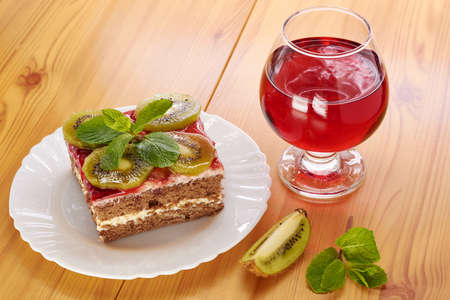 Glass of red wine and a dessert of kiwiの写真素材