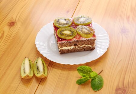 Sponge cake on a plate, decorated with kiwi slicesの写真素材