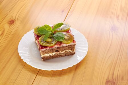 Sponge cake on a plate, decorated with kiwi slicesの写真素材
