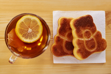 Black tea with lemon and cinnamon cupcake on a wooden tableの写真素材