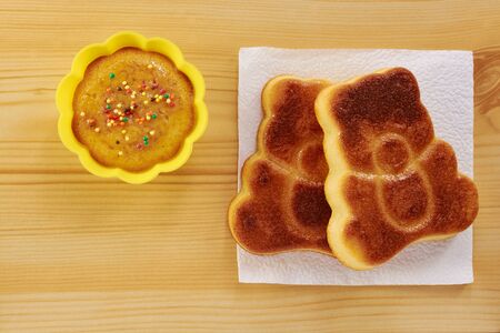 Cinnamon cake in the shape of a bear cub on a wooden tableの写真素材
