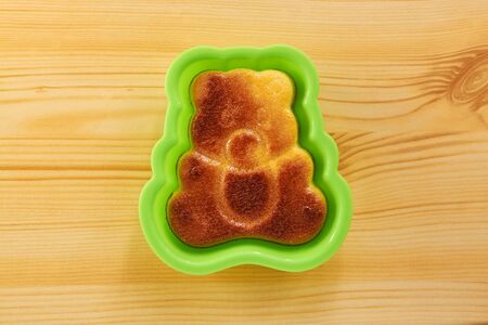 Cinnamon cake in the shape of a bear cub on a wooden tableの写真素材