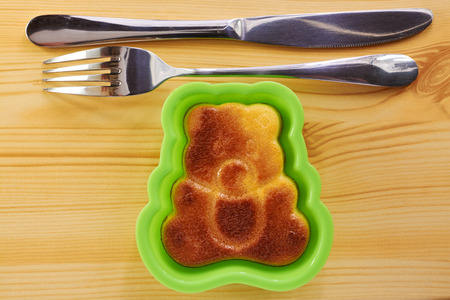 Cinnamon cake in the shape of a bear cub on a wooden tableの写真素材