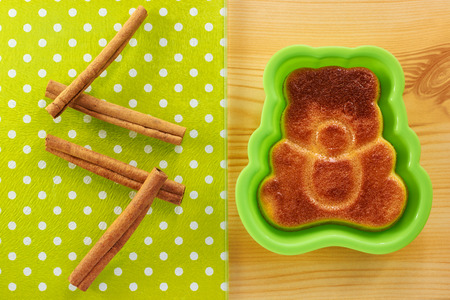 Cinnamon cake in the shape of a bear cub on a wooden tableの写真素材