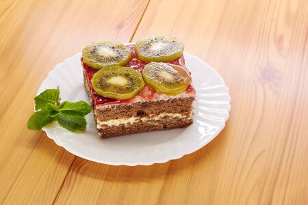 Sponge cake on a plate, decorated with kiwi slicesの写真素材