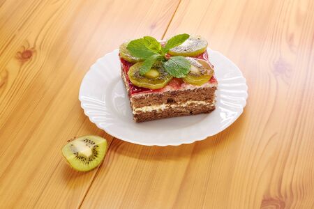 Sponge cake on a plate, decorated with kiwi slicesの写真素材