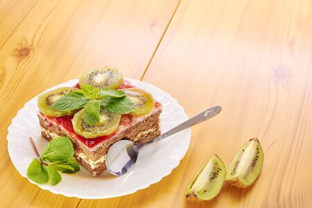 Sponge cake on a plate, decorated with kiwi slicesの写真素材