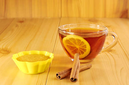 Black tea with lemon and cinnamon cupcake on a wooden tableの写真素材