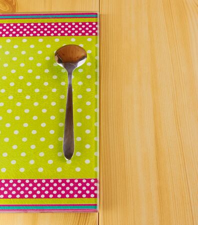 Teaspoon and green glass cutting board on a wooden tableの写真素材