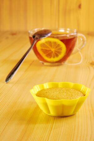 Black tea with lemon and cinnamon cupcake on a wooden tableの写真素材