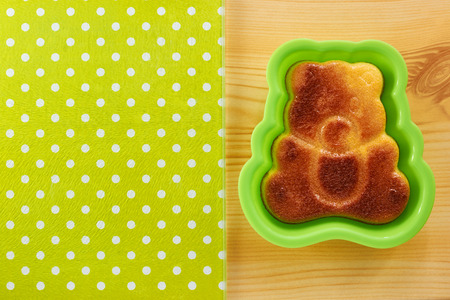 Cinnamon cake in the shape of a bear cub on a wooden tableの写真素材
