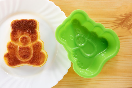 Cinnamon cake in the shape of a bear cub on a wooden tableの写真素材
