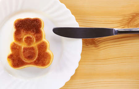 Cinnamon cake in the shape of a bear cub on a wooden tableの写真素材