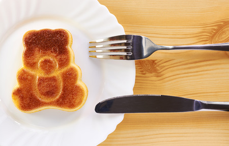 Cinnamon cake in the shape of a bear cub on a wooden tableの写真素材