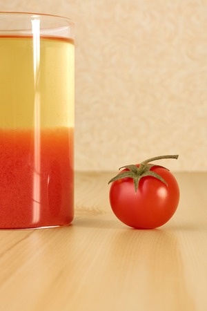 Juice and ripe cherry tomatoes on a wooden tableの写真素材