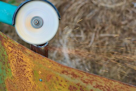 Angle grinder cuts rusty metal plate sparks ventの写真素材