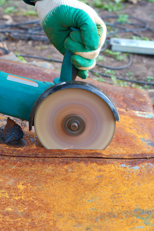 Angle grinder cuts rusty metal plate sparks ventの写真素材