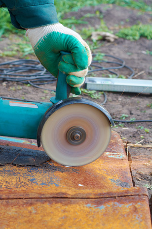 Angle grinder cuts rusty metal plate sparks ventの写真素材