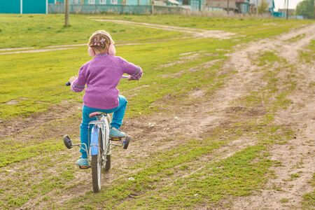 Girl riding a bike in a village in the springの写真素材
