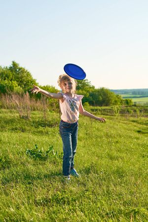 Girl playing flying disc in the park in summerの写真素材