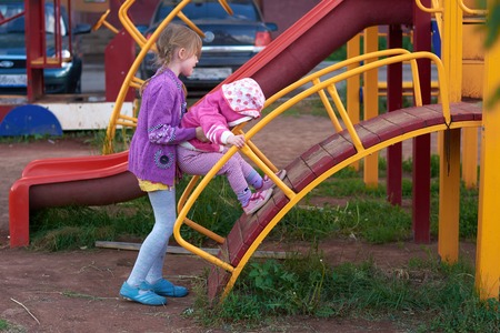 Two girls are playing on the playground in the springの写真素材