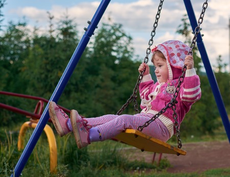 Girl riding on a swing in the springの写真素材