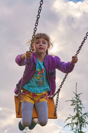 Girl riding on a swing in the springの写真素材