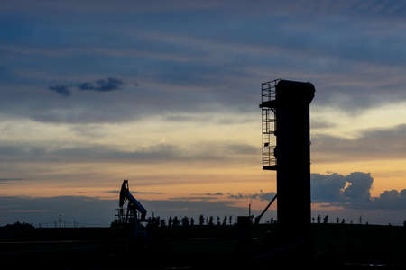 Oil machine rocking against the sky sunsetの写真素材