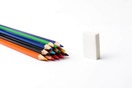 Colored pencils on white paper and erasersの写真素材