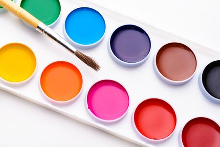 The palette of watercolor paints and brush on a white backgroundの写真素材