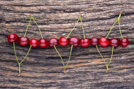 Ripe cherry lying on an old wooden tableの写真素材