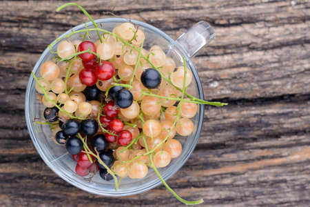 Currants in a transparent cup on the old wooden tableの写真素材