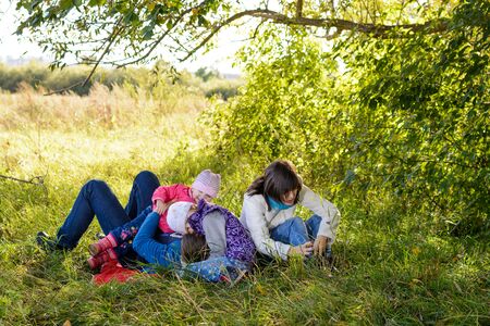Family resting in the meadow on a sunny autumn dayの写真素材