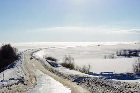 Winter snow-covered winding road on a sunny dayの写真素材