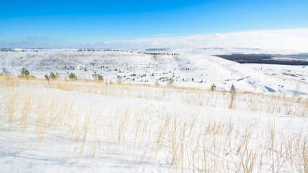 Panoramic view of the snow-covered hills on a sunny dayの写真素材
