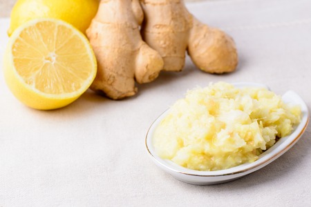 A mixture of grated ginger and lemon on a saucerの写真素材