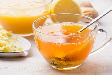 Cup of tea with lemon, honey and ginger on a napkinの写真素材