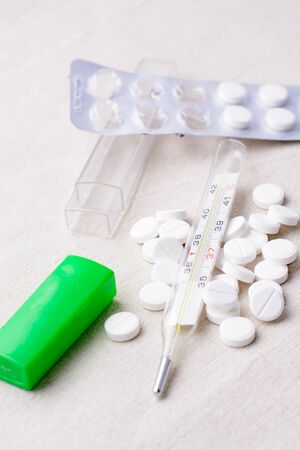 Thermometer and pills scattered round on sackingの写真素材