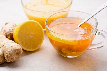 Cup of tea with lemon, honey and ginger on a napkinの写真素材