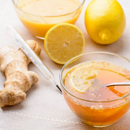 Cup of tea with lemon, honey and ginger on a napkinの写真素材