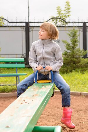 Girl riding on a swing and face contortsの写真素材