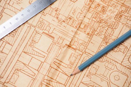 Measuring and drawing instruments and old drawings are on the tableの写真素材