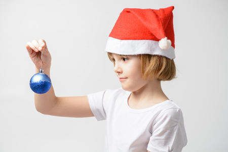 Girl in santa hat holding a Christmas ballの写真素材