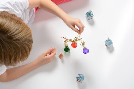 Girl playing with Christmas decorations on a white backgroundの写真素材