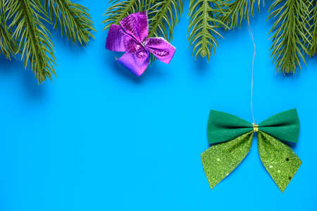 Green ribbon on spruce branches on a blue backgroundの写真素材