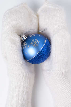 White woolen mittens with a Christmas toy on a white backgroundの写真素材