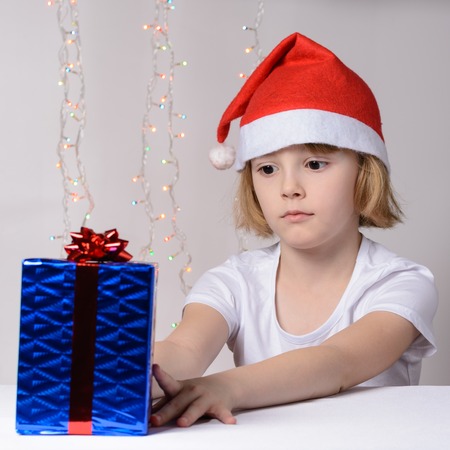 Little girl in santa hat Christmas gift packsの写真素材