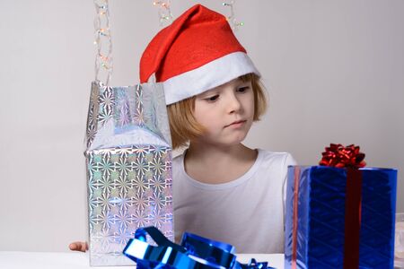 Little girl in santa hat Christmas gift packsの写真素材