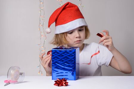 Little girl in santa hat Christmas gift packsの写真素材